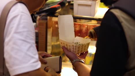 vendor prepares and serves buns to customer