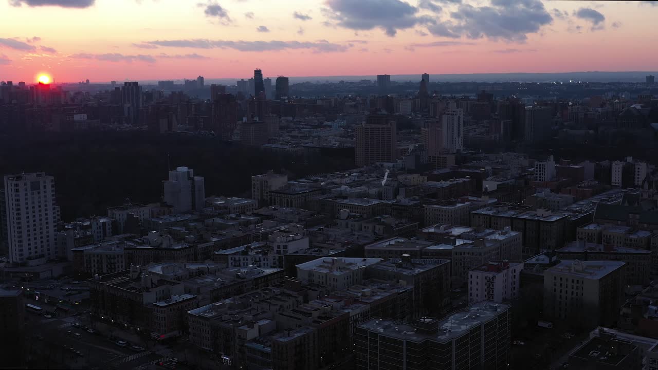 Letecký přelet nad čtvrtí Harlem v New Yorku s nádherným zapadajícím sluncem a viditelnými mraky