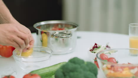 Closeup-man-hands-smashing-eggs-over-glass-bowl-in-slow-motion.