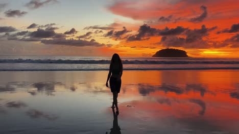 woman walking on beach at sunset