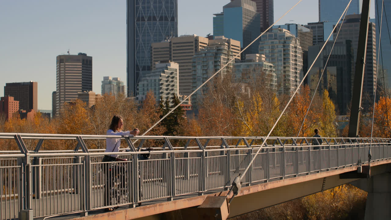 vista lateral de un joven caucásico tomando café en el puente de la ciudad 4k