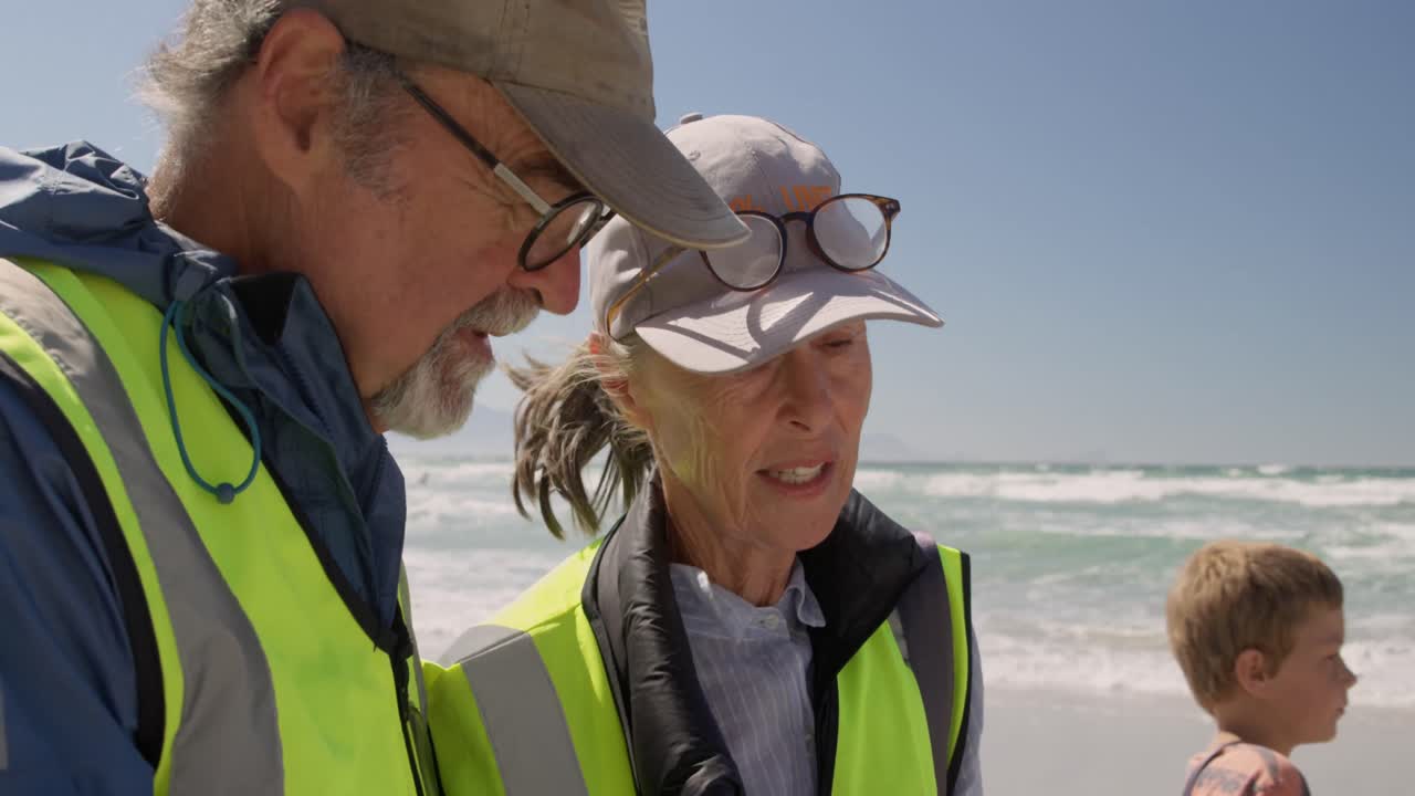 voluntarios de alto nivel interactuando entre sí en la playa 4k
