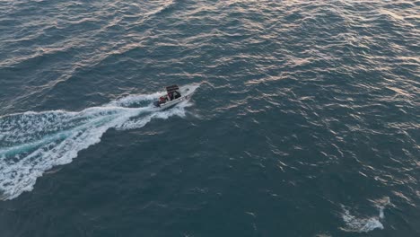 Speedboat-cruising-on-deep-blue-water,-aerial-view,-sunny-day-in-Genoa,-Italy