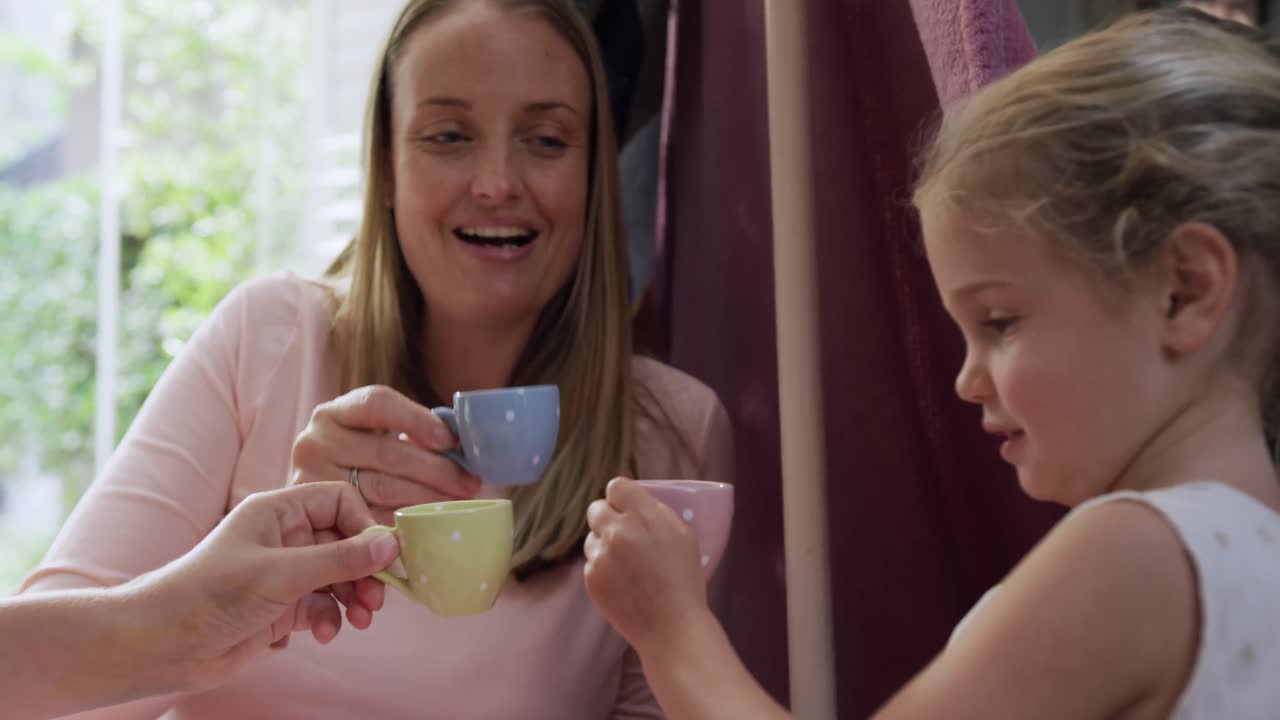 Mother and daughters playing dinette together
