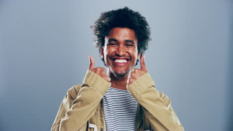 a young man showing thumbs up against a grey