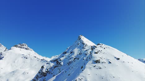 snowy alpine landscape under clear blue sky, valle d'aosta, italy. aerial drone panoramic view, copy space