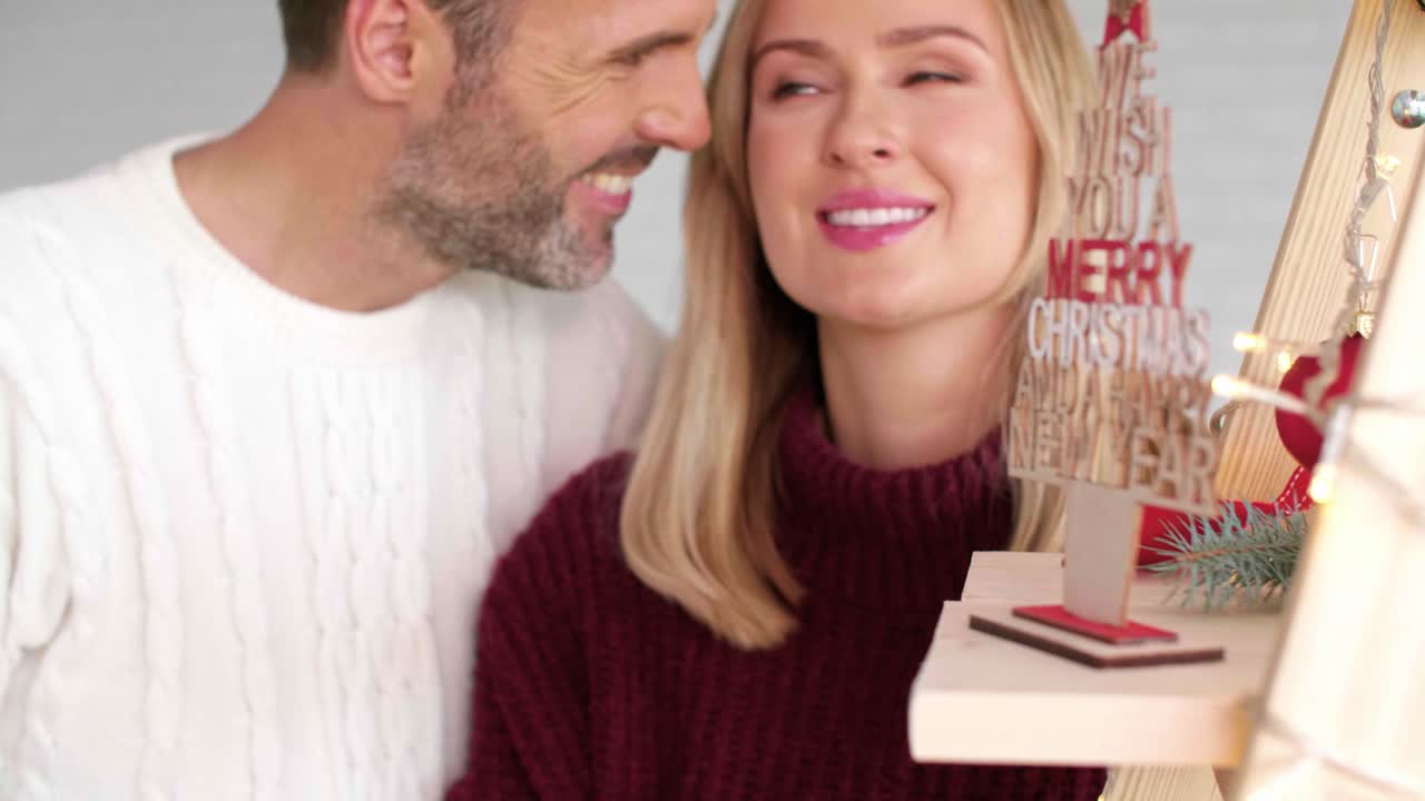 hombre sonriente abrazando a su novia en navidad