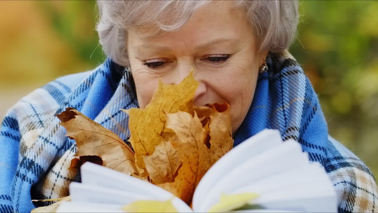Senior Woman Reading in Autumn Park