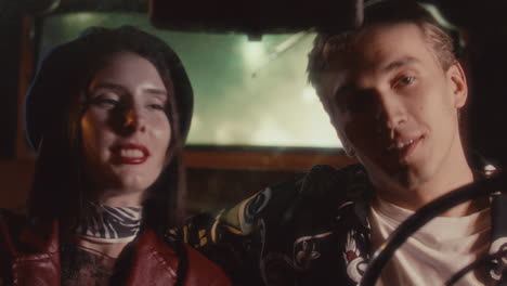 young romantic couple enjoying night drive in vintage car