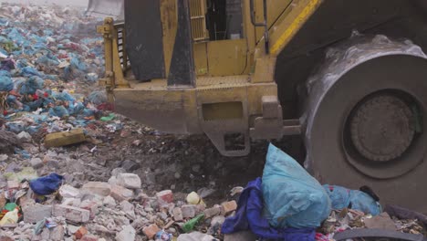 vehículos que limpian la basura apilada en un vertedero lleno de basura