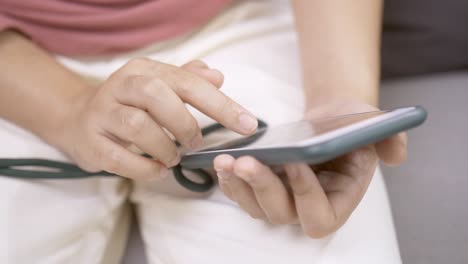 Close-up-focus-on-woman-hands-using-a-smartphone-to-social-media