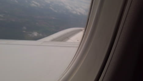 blurred landscape through the window of an airplane by a gray weather