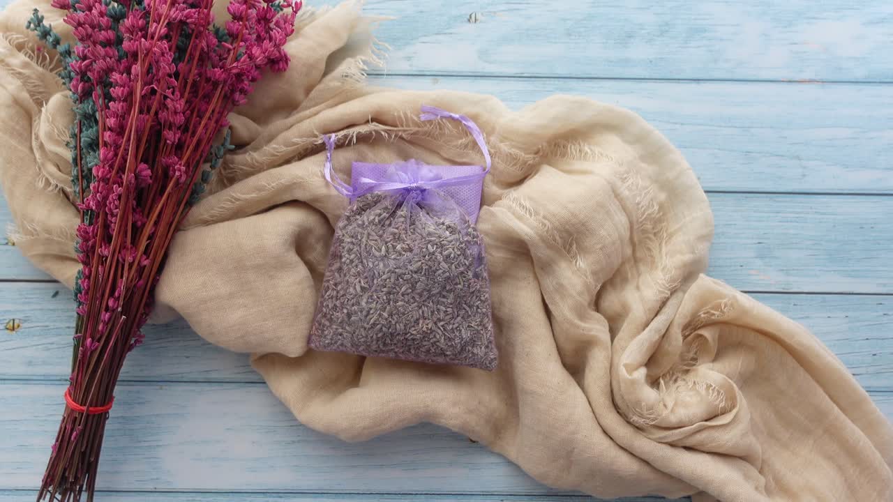 나무 테이블 에 건조 한 라벤더 꽃다발 과 직물 배열