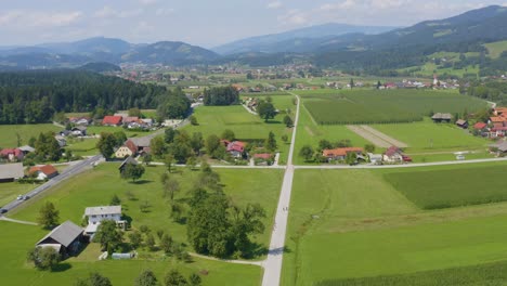Aerial-view-of-Slovenj-Gradec-town-in-Slovenia-with-homes,-farms-and-roads-below,-Drone-dolly-out-reveal-shot