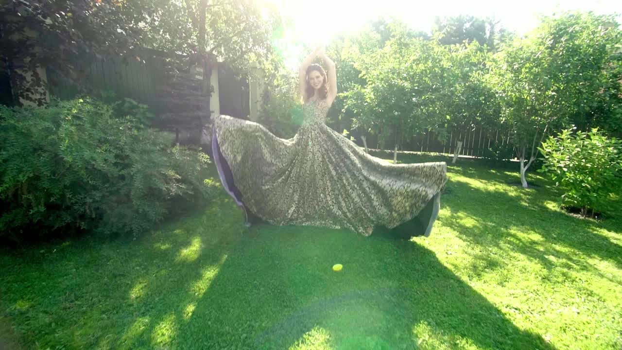 Woman in a Beautiful Gold Dress in a Garden