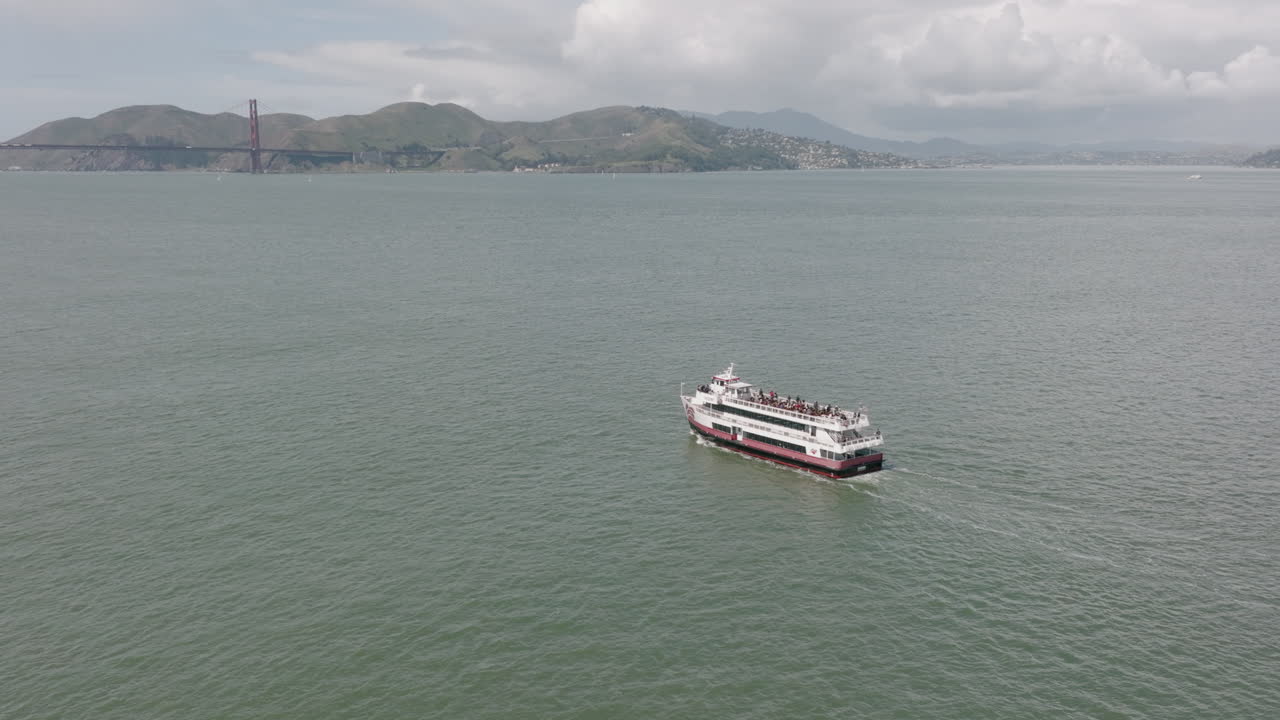 toma aérea giratoria de ferry con puente golden gate en segundo plano en san francisco, ca