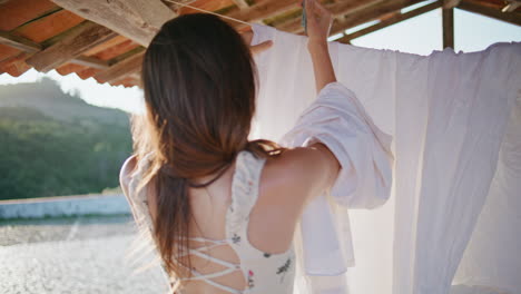 involved girl putting laundry at rope summer nature. woman holding white clothes