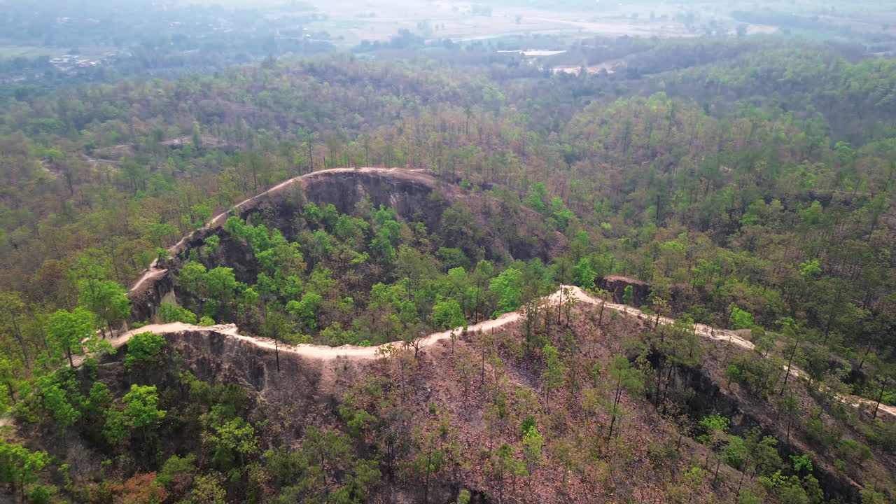 Drone glides over sharp ridges and deep drops of Pai Canyon in golden hour light