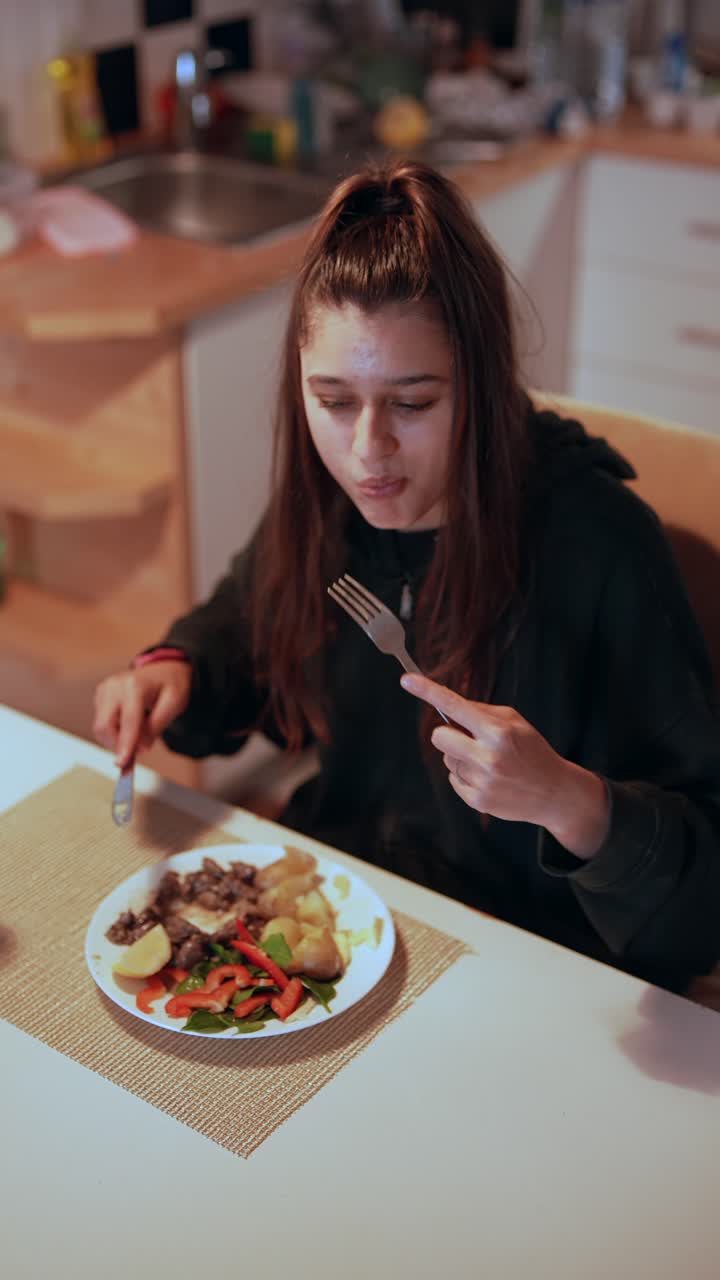 Woman Eating Dinner at Kitchen Table