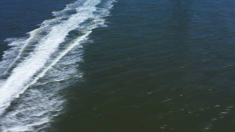 A-low-angle-view-over-a-pair-of-watercrafts-on-a-sunny-day,-racing-towards-the-camera