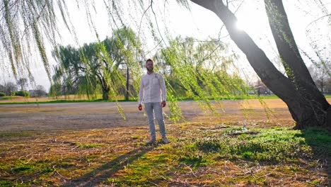 adult singer man singing under a weeping willow tree at a gold course in washington dc during a gorgeous sunset