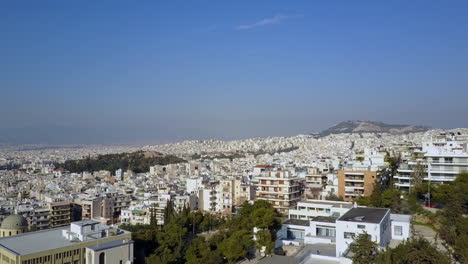 aerial shot moving backwards past buildings in athens greece, 4k