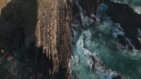 breathtaking view of waves crashing and washing over the sharp cliffs of portugal's west coast