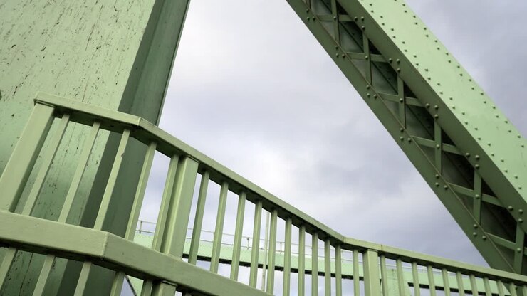 Ponte de aço industrial com estrutura de suporte de vigas robustas, movimento lateral para a direita, olhando para cima