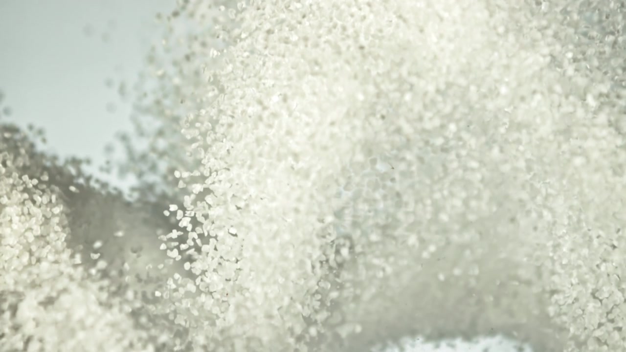Esplosione dinamica di particelle di zucchero bianco o sale al rallentatore