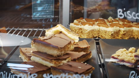 carrot cakes, flapjacks, caramels slices and walnut cake deserts in a cafe restaurant counter bar display case