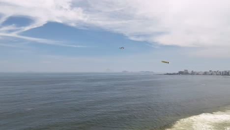 drone over copacabana beach in rio de janeiro with airplane pulling promo banner