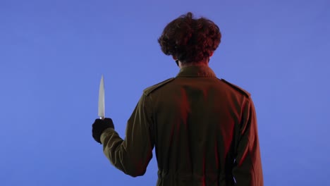 man in white mask with big sharp knife on blue background with red neon light image of jason