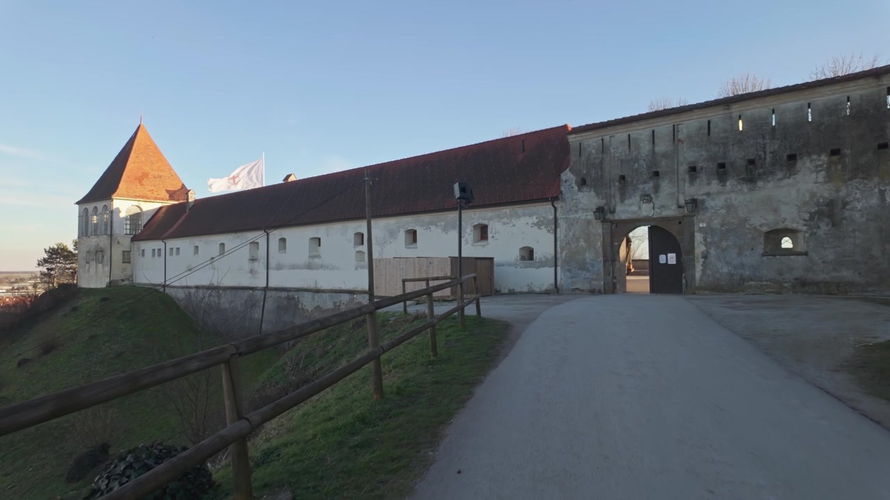 Castello di Ptuj a Ptuj, Slovenia, fortezza medievale in cima a una collina con torri, merli e mura in pietra che domina la città, punto di riferimento storico europeo e sito patrimonio.