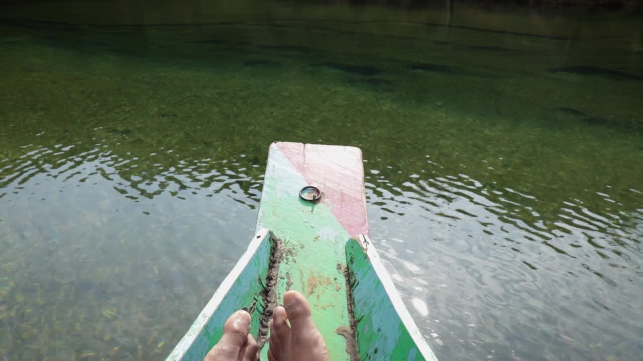 young man foot at wood boat at river shore from top angle in details