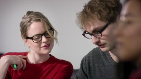 positive vibes in office meeting between men and women with glasses and red top