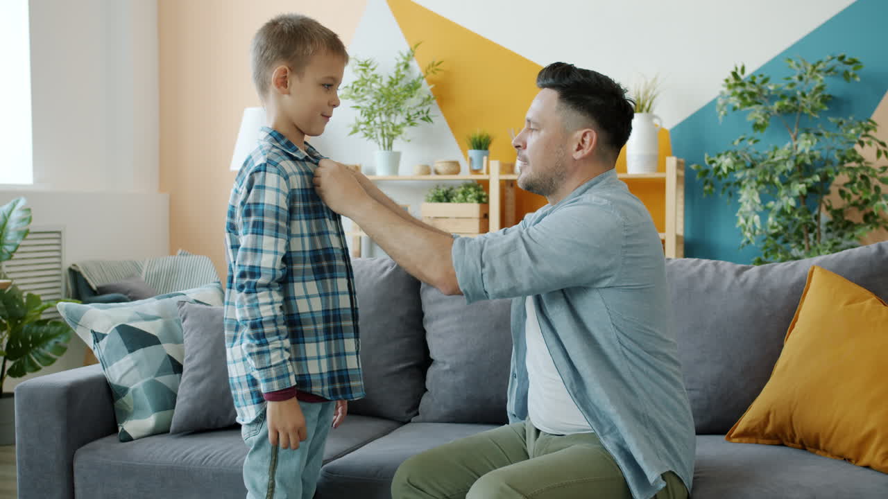 Father helping son get dressed