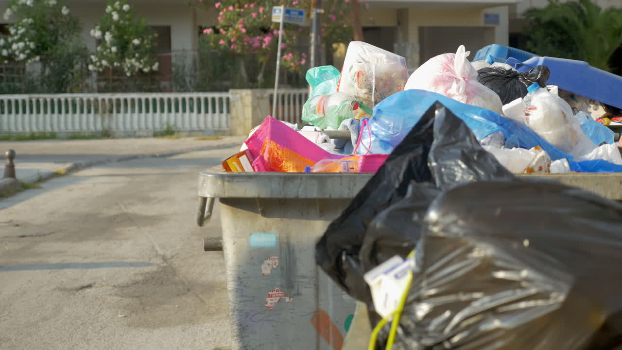 mujer arrojando una botella de plástico a la basura de la calle