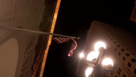 us flag hanging on a building next to a vintage a street lamp and moving