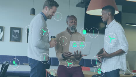 animation of ecology icons over diverse colleagues using laptop and discussing work in office