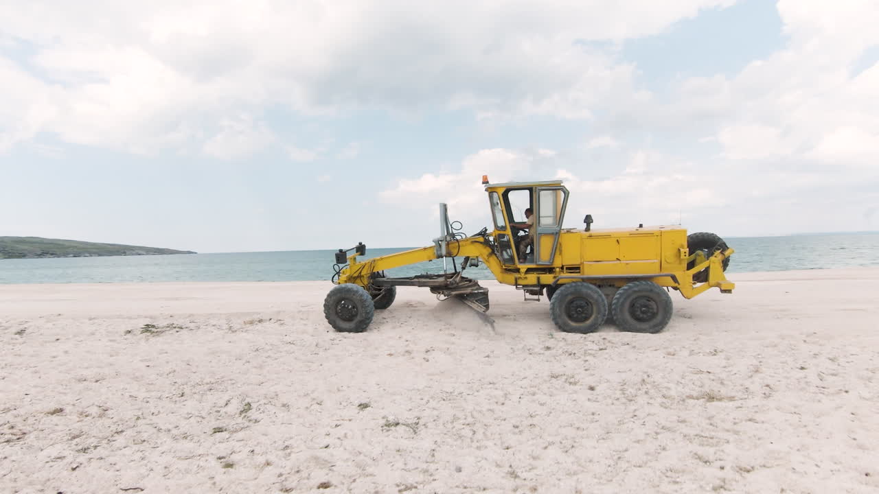 Yellow Grader Working on a Beach