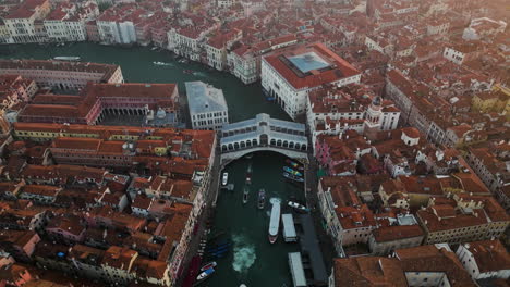 aerial view of the famous grand canal and rialto bridge in venice, italy at sunrise - drone shot