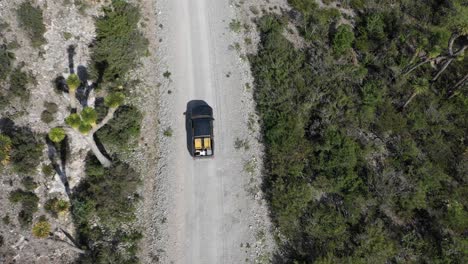 Top-view-by-drone-of-a-car-vw-amarok-driving-through-mexican-wasteland-on-dirt-road