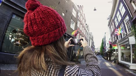 girl takes photo of dutch street with lgbt diversity flags in amsterdam holland