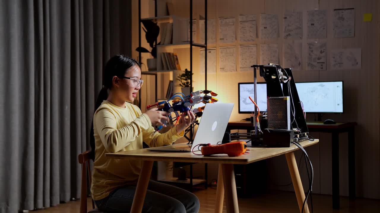 집에서 사이보그 손을 확인하는 노트북을 가진 아시아 십대 소녀