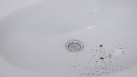 bathroom sink with hair from trimming beard - slow motion