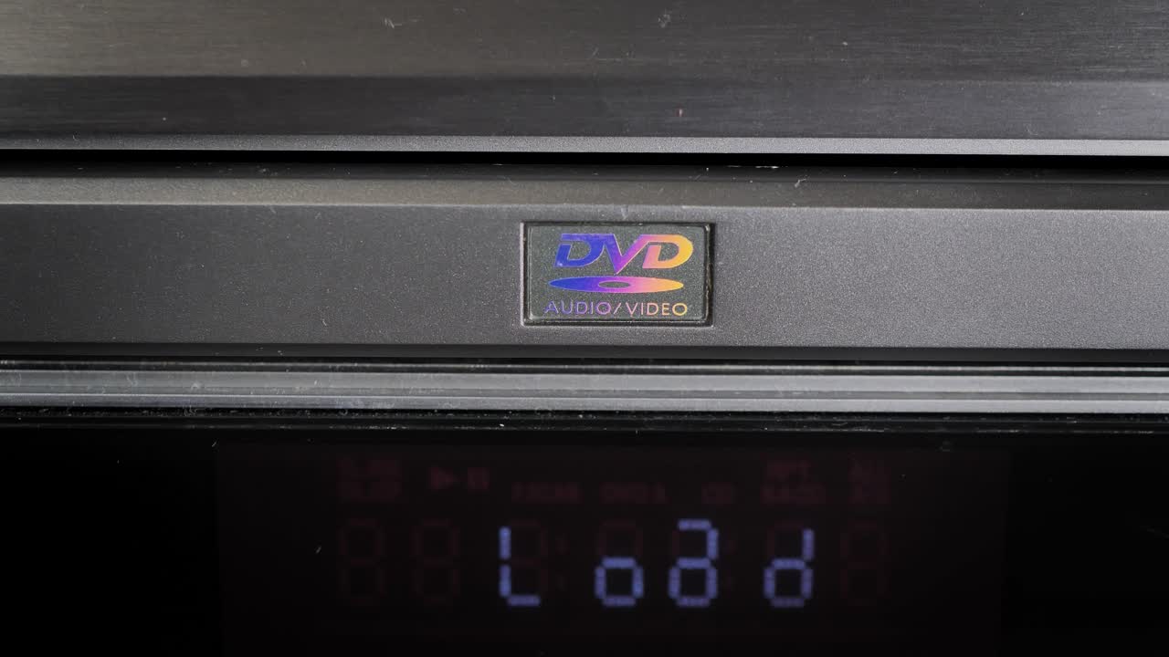 DVD player. Disc installation. Man plays DVD, CD on a player. Front, top view. Static shot.