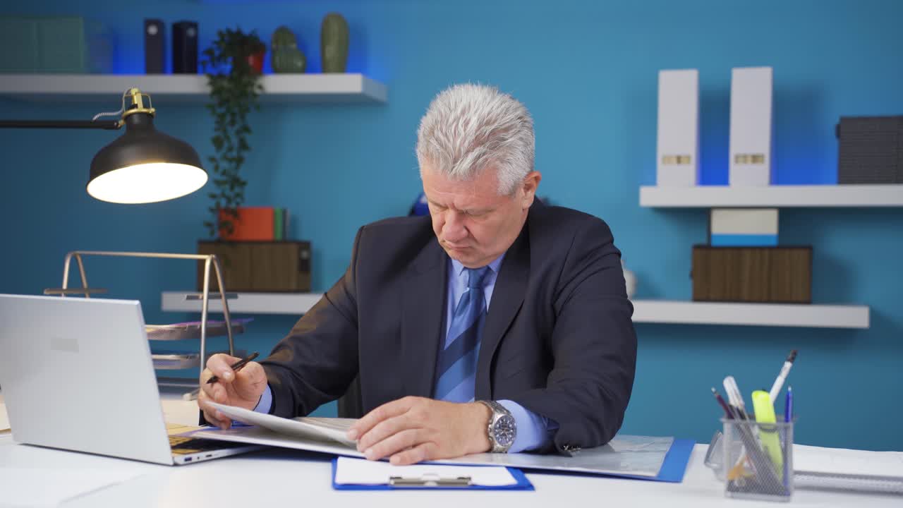 hombre de negocios trabajando mirando archivos de papeleo.