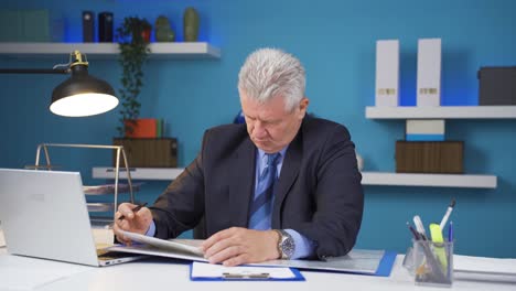 hombre de negocios trabajando mirando archivos de papeleo.