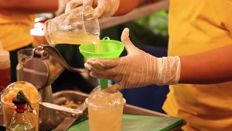 pouring a drink into a cup with ice