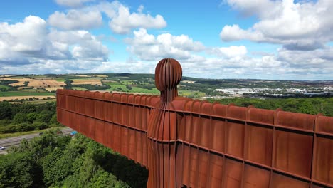 close aerial view, then to a wide shot of the angel of the north statue